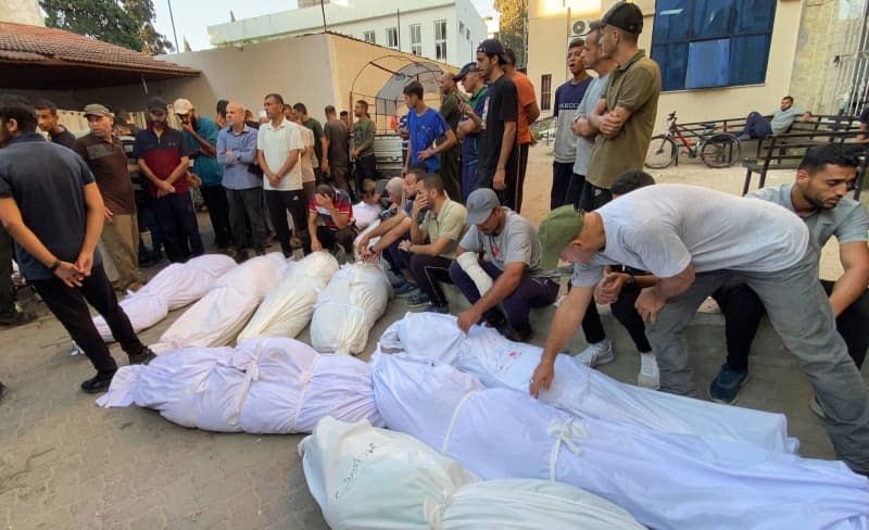 People mourn over the bodies of Palestinians killed in an Israeli attack on the Al-Tabeen school, which housed displaced Palestinians in Gaza City, at al-Maamadani hospital. At least 100 people were killed and dozens more were injured. Hadi Daoud/APA Images via ZUMA Press Wire/dpa