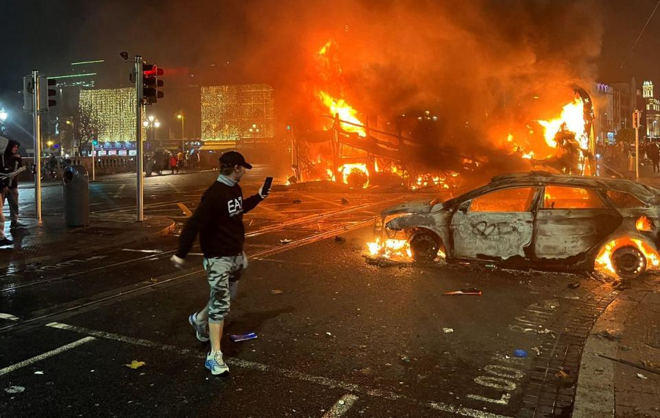 Police cars were set alight while fireworks were thrown towards officers (AFP via Getty Images)