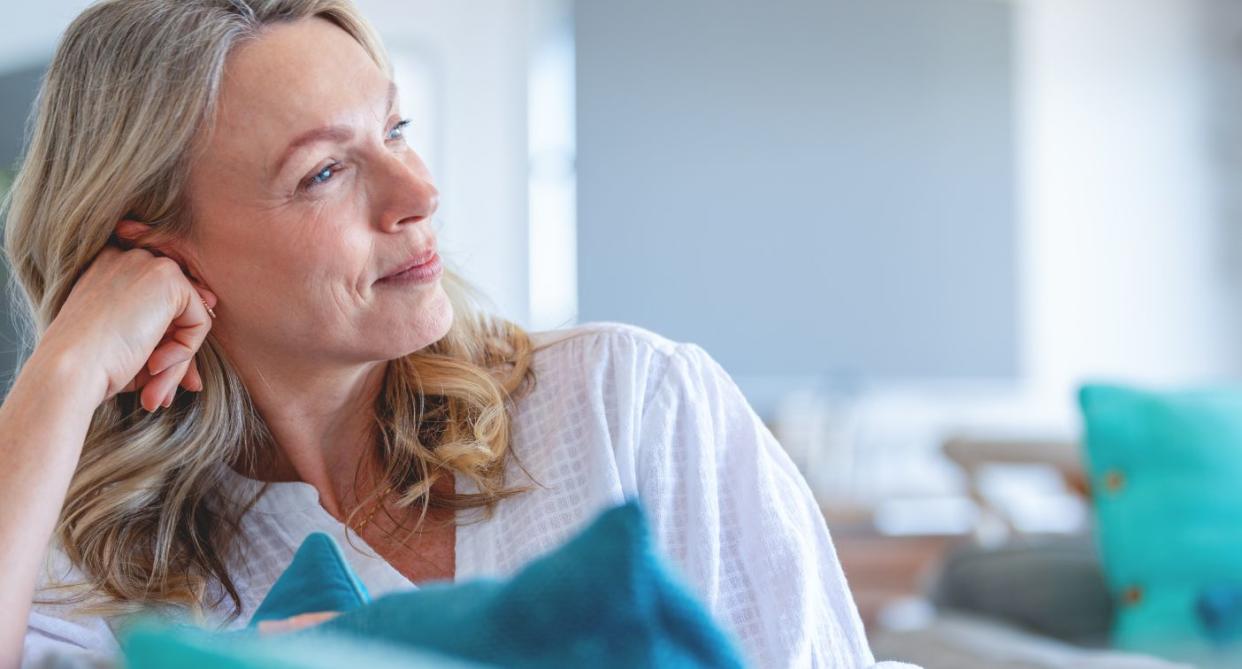 Menopause myths - middle aged woman smiling on sofa. (Getty Images)