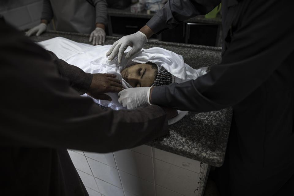 The body of Palestinian Muhammad Hassouna, who was killed in an Israeli airstrike is prepared for his funeral at a hospital in Rafah, in the southern Gaza Strip, Sunday, Aug. 7, 2022. An Israeli airstrike in Rafah killed a senior commander in the Palestinian militant group Islamic Jihad, authorities said Sunday, its second leader to be slain amid an escalating cross-border conflict. (AP Photo/Fatima Shbair)