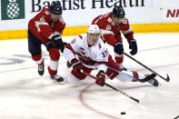 Carolina Hurricanes right wing Andrei Svechnikov (37) passes the puck as Florida Panthers center Sam Bennett (9) and defenseman Markus Nutivaara (65) defend during the second period of an NHL hockey game Thursday, April 22, 2021, in Sunrise, Fla. (AP Photo/Marta Lavandier)