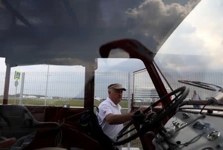 Swiss fan Beat Studer looks at an old-time tractor after driving with two friends, from home to Kaliningrad stadium to watch their team playing against Serbia, in Kaliningrad, Russia June 21, 2018. REUTERS/Mariana Bazo