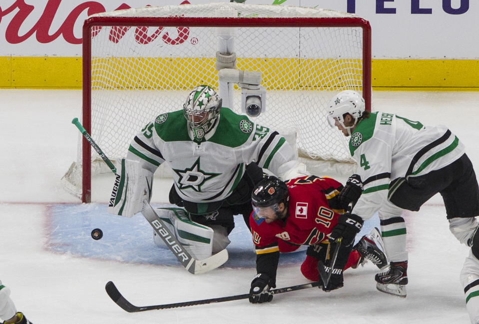 Calgary Flames' Derek Ryan (10) is stopped by Dallas Stars goalie Anton Khudobin (35) as Stars' Miro Heiskanen (4) defends during first-period NHL Western Conference Stanley Cup hockey playoff action in Edmonton, Alberta, Sunday, Aug. 16, 2020. (Jason Franson/The Canadian Press via AP)