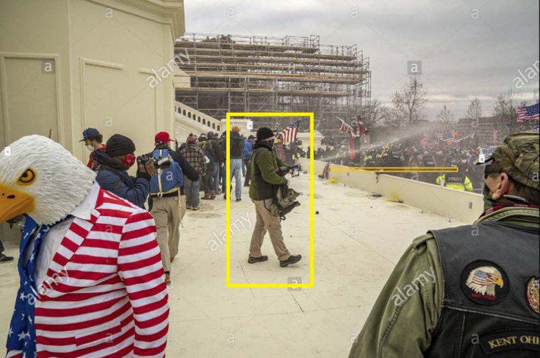 A photo from court documents shows the man the FBI says is Gregory Yetman, firing a canister of pepper spray during the Jan. 6, 2021 Capitol riot.