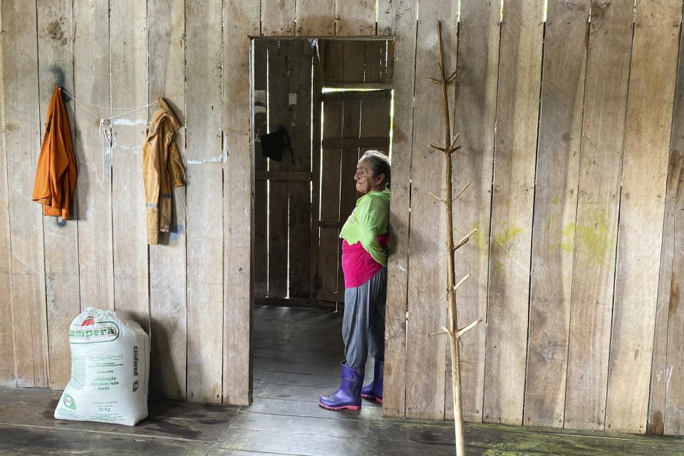 Maria de Fatima da Costa, madre de Amarildo da Costa de Oliveira, quien confesó haber matado al experto indígena Bruno Pereira y al periodista británico Dom Phillips, de pie en la puerta de entrada de su casa en la comunidad de Sao Gabriel, en el estado de Amazonas, Brasil, el 1 de marzo de 2023. (AP Foto/Fabiano Maisonnave)