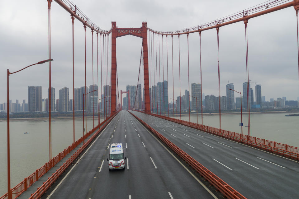 FILE - In this Jan. 25, 2020, file photo, an ambulance drives across a nearly empty bridge in Wuhan in central China's Hubei Province. The Chinese city of Wuhan is looking back on a year since it was placed under a 76-day lockdown beginning Jan. 23, 2020. (Chinatopix via AP, File)