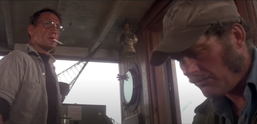 Two men sit in the cabin of a boat