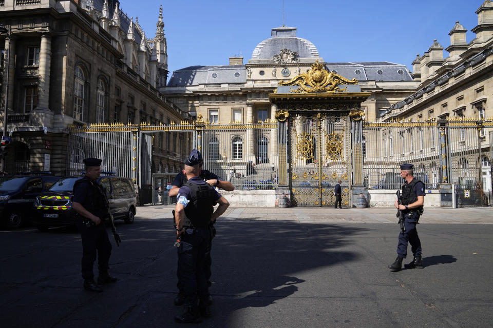 Police officers guard the Palace of Justice Wednesday, Sept. 8, 2021 in Paris. France on Wednesday will begin the trial of 20 men accused in the Islamic State group's 2015 attacks on Paris that left 130 people dead and hundreds injured. Among the plantiffs are nearly 1,800 victims, including survivors who suffered physical or psychological harm and families whose loved ones died that night. A total of 330 lawyers are representing them and the defendants. (AP Photo/Michel Euler)