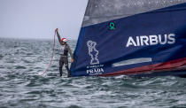 A crewman from United States' American Magic boat Patriot signals for assistant after it capsized during its race against Italy's Luna Rossa on the third day of racing of the America's Cup challenger series on Auckland's Waitemate Harbour, New Zealand, Sunday, Jan. 17, 2021. (Michael Craig/NZ Herald via AP)