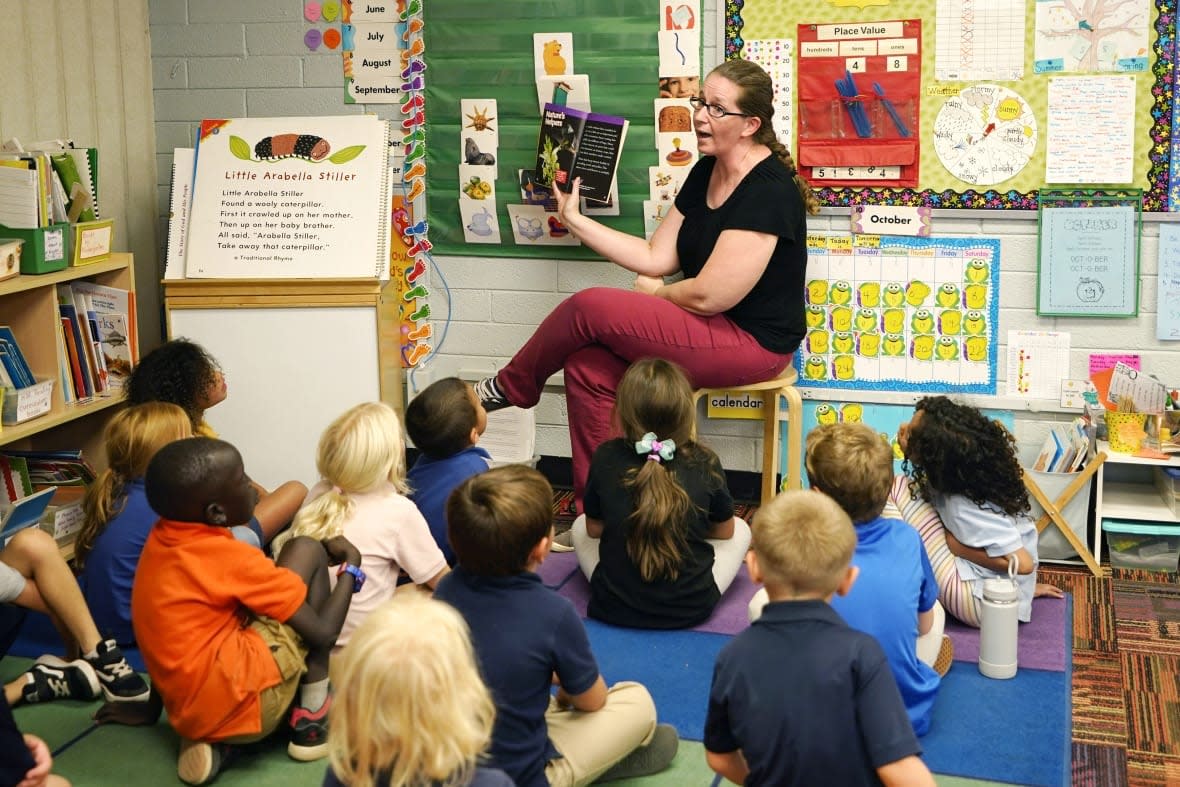 Kindergarten teacher Lynola Vis reads a book in class at Phoenix Christian School PreK-8 in Phoenix, Tuesday, Oct. 25, 2022. School choice allows taxpayer money to pay for private school tuition instead of only financing public schools. (AP Photo/Ross D. Franklin)
