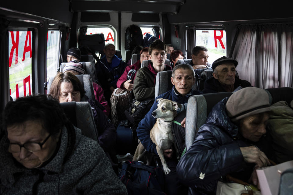 People sit in a bus during evacuation from Lyman, Donetsk region, eastern Ukraine, Saturday, April 30, 2022. (AP Photo/Evgeniy Maloletka)