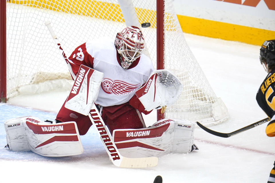 Pittsburgh Penguins' Teddy Blueger, right, shoots over Detroit Red Wings goaltender Alex Nedeljkovic for a goal during the first period of an NHL hockey game in Pittsburgh, Sunday, March 27, 2022. (AP Photo/Gene J. Puskar)