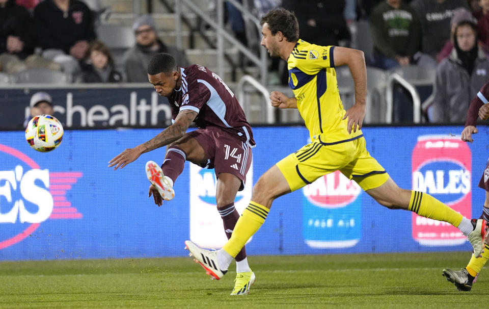 Colorado Rapids forward Calvin Harris, left, kicks the ball as Nashville SC defender Jack Maher covers during the first half of an MLS soccer match Saturday, March 2, 2024, in Commerce City, Colo. (AP Photo/David Zalubowski)