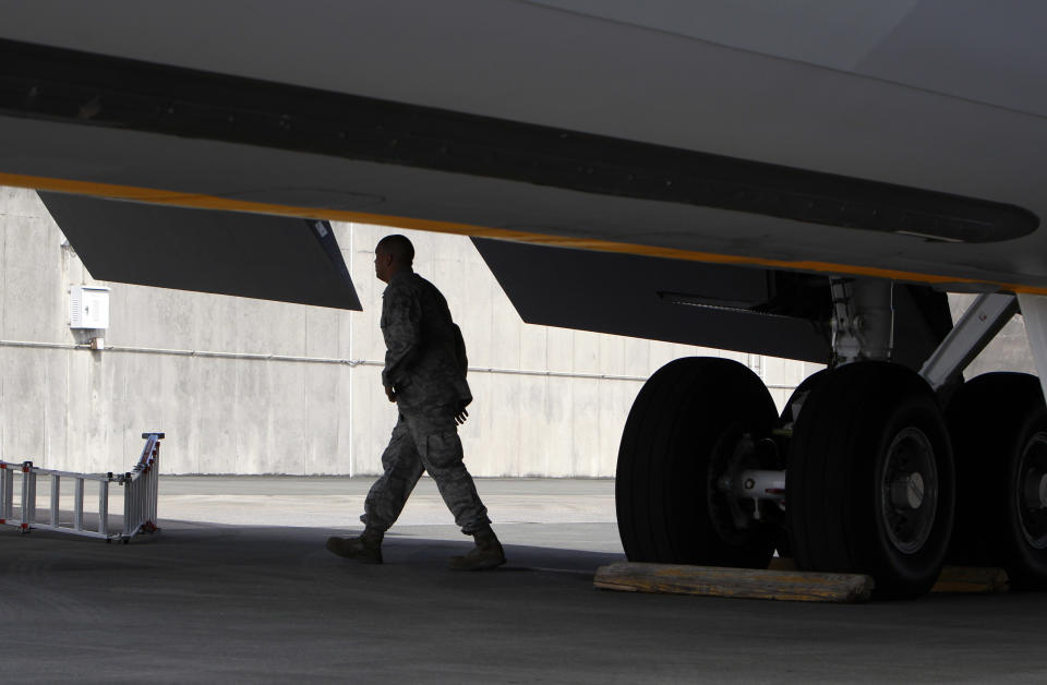 In this Aug. 14, 2012 photo, a ground crew member walks under the wing of a U.S. Air Force KC-135 Stratotanker, which was built in 1958, at Kadena Air Base on Japan's southwestern island of Okinawa. For decades, the U.S. Air Force has grown accustomed to such superlatives as unrivaled and unbeatable. Now some of its key aircraft are being described with terms like decrepit. (AP Photo/Greg Baker)