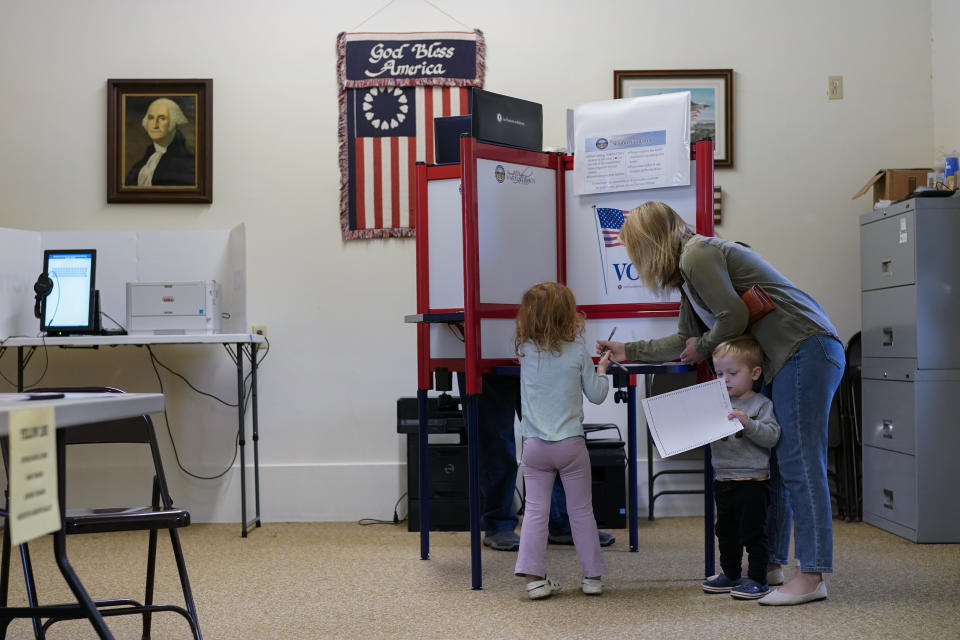 Lauren Miracle, helps her children Dawson, 1, and Oaklynn, 3, fill out children's practice ballots before voting herself at a polling location in the Washington Township House in Oregonia, Ohio, Tuesday, Nov. 7, 2023. Polls are open in a few states for off-year elections that could give hints of voter sentiment ahead of next year's critical presidential contest. (AP Photo/Carolyn Kaster)
