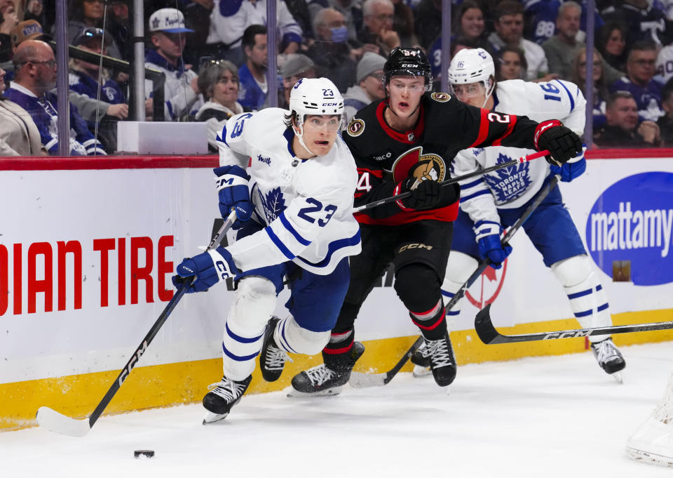 Toronto Maple Leafs left wing Matthew Knies (23) skates with the puck away from Ottawa Senators defenseman Jacob Bernard-Docker (24) during third-period NHL hockey game action in Ottawa, Ontario, Saturday, Feb. 10, 2024. (Sean Kilpatrick/The Canadian Press via AP)