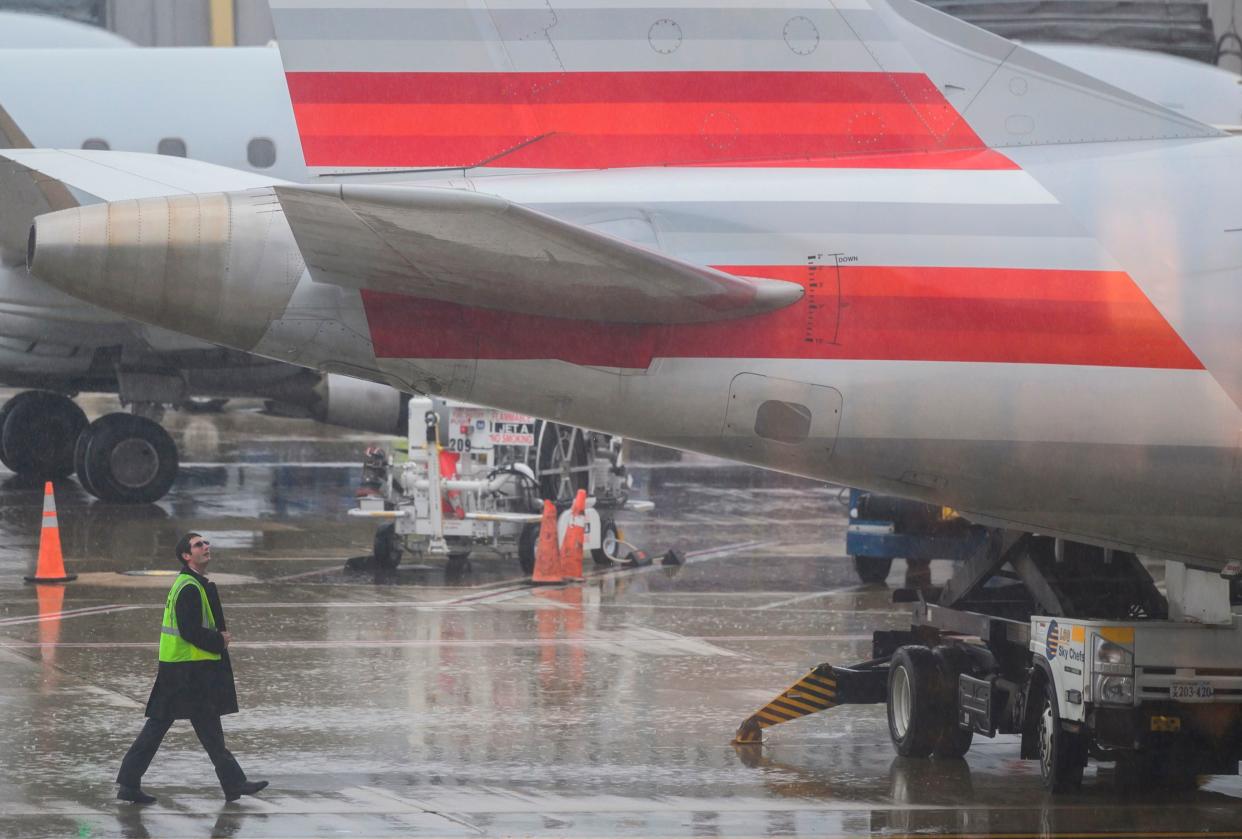 An American Airlines safety inspector checks a plane on the tarmac at Ronald Reagan Washington National Airport in Arlington, Va. Thursday. American Airlines executives warned of significant travel delays if the US government shutdown goes on much longer, but said that customer demand has not been significantly affected thus far.