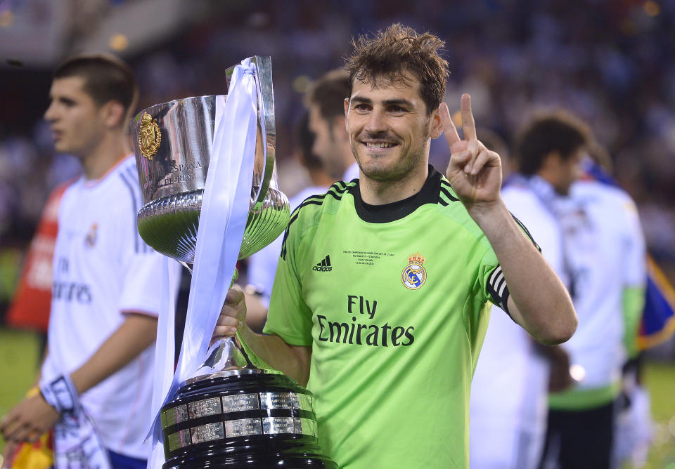 Real goalkeeper Iker Casillas poses with the trophy at the end of the final of the Copa del Rey between FC Barcelona and Real Madrid at the Mestalla stadium in Valencia, Spain, Wednesday, April 16, 2014. Real defeated Barcelona 2-1. (AP Photo/Manu Fernandez)