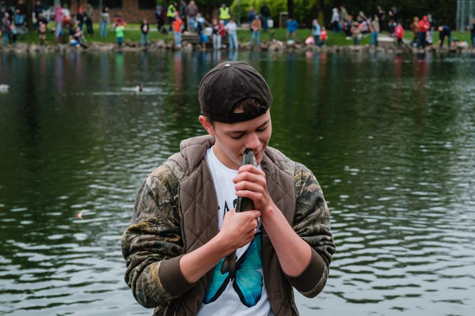 Michael Hann, 15, of New Philadelphia makes a special connection with a rainbow trout caught by a friend during the inaugural trout derby last weekend at the Tuscora Park Pond in New Philadelphia.