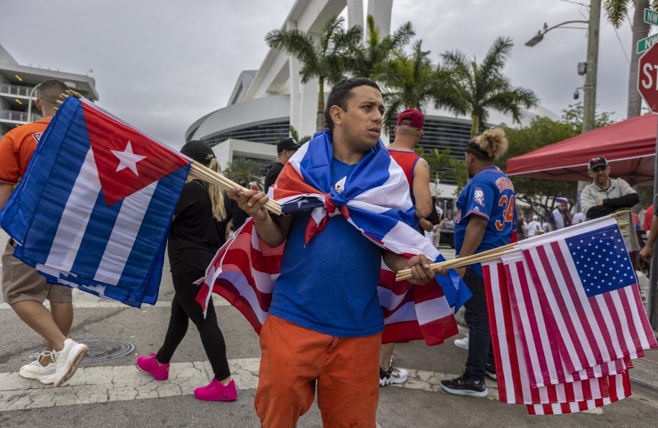 A vendor sells U.S. and Cuban flags outside the stadium before World Baseball Classic game between Cuba and the United States on Sunday, March 19, 2023, in Miami. (Jose A. Iglesias/Miami Herald via AP)