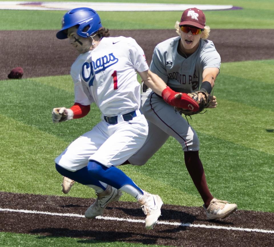 Westlake Chaparrals Braeden Babb (1) escapes the run down tag from Round Rock Dragons short stop Hudson Ellis (2) and returns safe on third base during the first inning at the Class 6A regional quarterfinal baseball playoff on Saturday, May 20, 2023, at the Tornado Boftball Field at Concordia University.