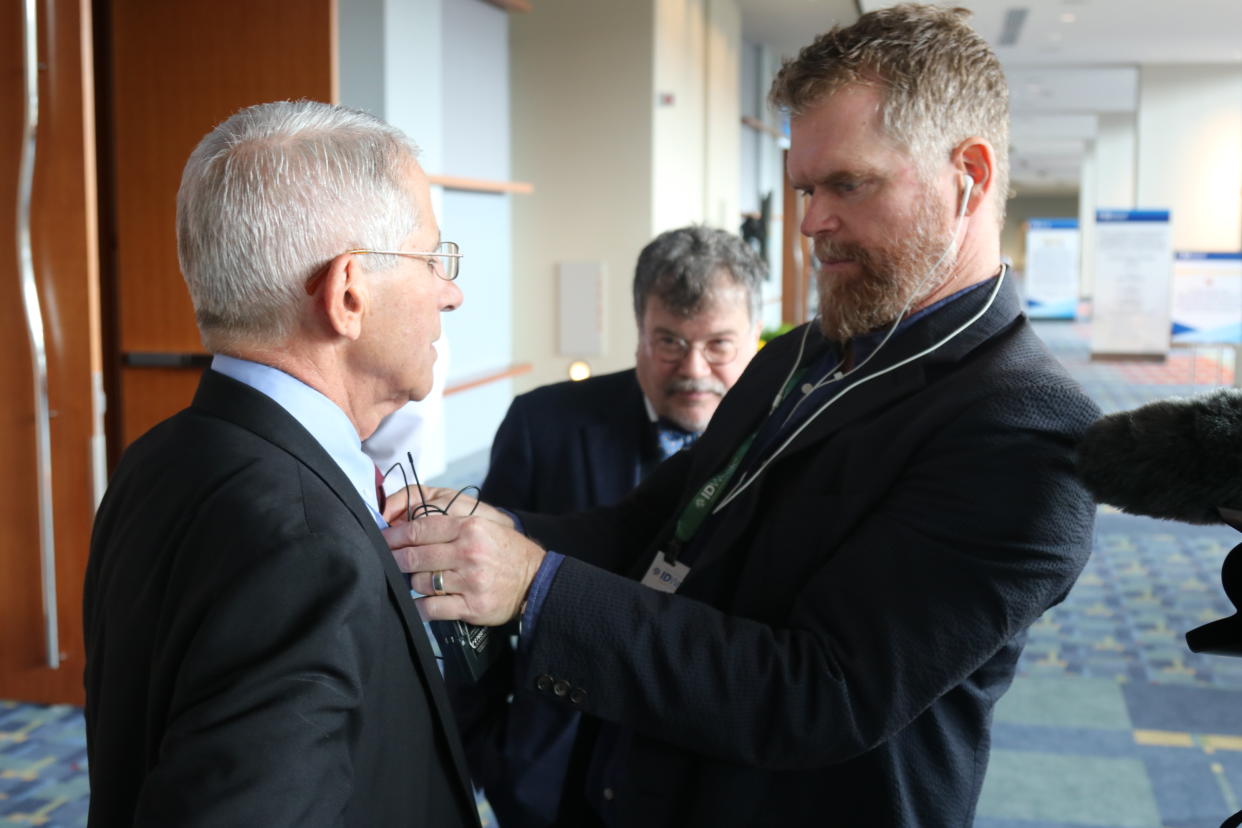 Director Scott Hamilton Kennedy seen placing a mic on Dr. Anthony Fauci before shooting a scene for Shot in the Arm. (Curved Light Productions) 