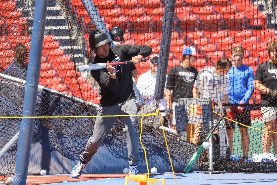 Winnacunnet High School baseball coach Aaron Abood lays down a bunt during Friday's batting practice session at Fenway Park.