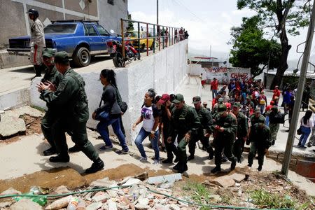 Venezuelan army officers and soldiers walk through San Pedro slum as part of military drills in Caracas, Venezuela, May 20, 2016. REUTERS/Marco Bello