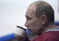 Russian President Vladimir Putin drinks from a cup during a friendly ice hockey match in the Bolshoi Ice Palace near Sochi January 4, 2014. REUTERS/Alexei Nikolskiy/RIA Novosti/Kremlin (RUSSIA - Tags: POLITICS SPORT OLYMPICS ICE HOCKEY) ATTENTION EDITORS - THIS IMAGE HAS BEEN SUPPLIED BY A THIRD PARTY. IT IS DISTRIBUTED, EXACTLY AS RECEIVED BY REUTERS, AS A SERVICE TO CLIENTS