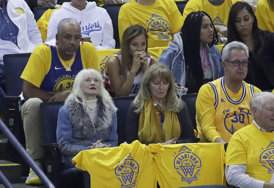 Dell Curry, top left, and his wife, Sonya, second from left, the parents of Golden State Warriors guard Stephen Curry and Portland Trail Blazers guard Seth Curry, watch from their seats next to Ayesha Curry during the first half of Game 1 of the NBA basketball playoffs Western Conference finals between the Warriors and the Trail Blazers in Oakland, Calif., Tuesday, May 14, 2019. Ayesha Curry is the wife of Stephen Curry. (AP Photo/Jeff Chiu)