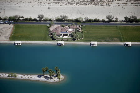 Homes with swimming pools and boathouses built around an artificial lake are seen in Indio, California, April 13, 2015. REUTERS/Lucy Nicholson