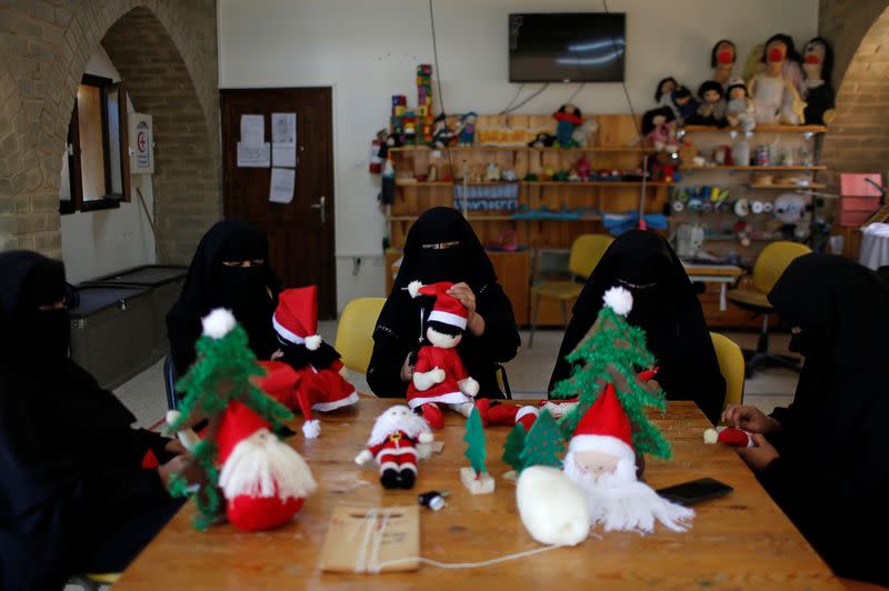 Palestinian women wearing face veil, niqab, make Santa-themed Christmas toys in the northern Gaza Strip