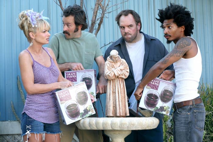 four characters pouring boxed wine into an outside fountain