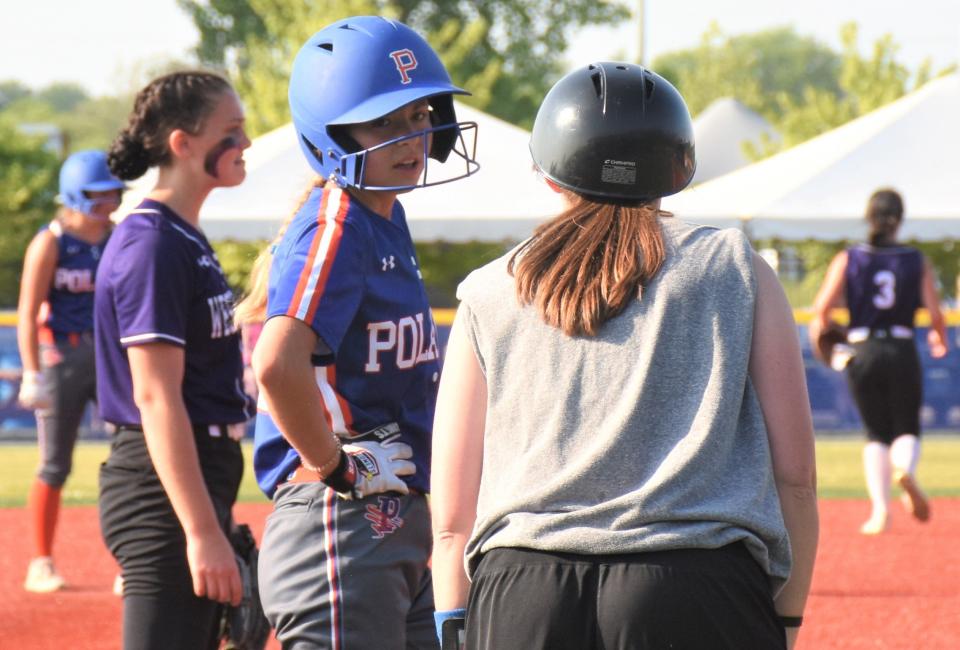 Poland Tornado Shelbi Hagues (left) confers with coach Erin Meeker while standing on third base during the second inning of Section III's May 30 Class D championship softball game.