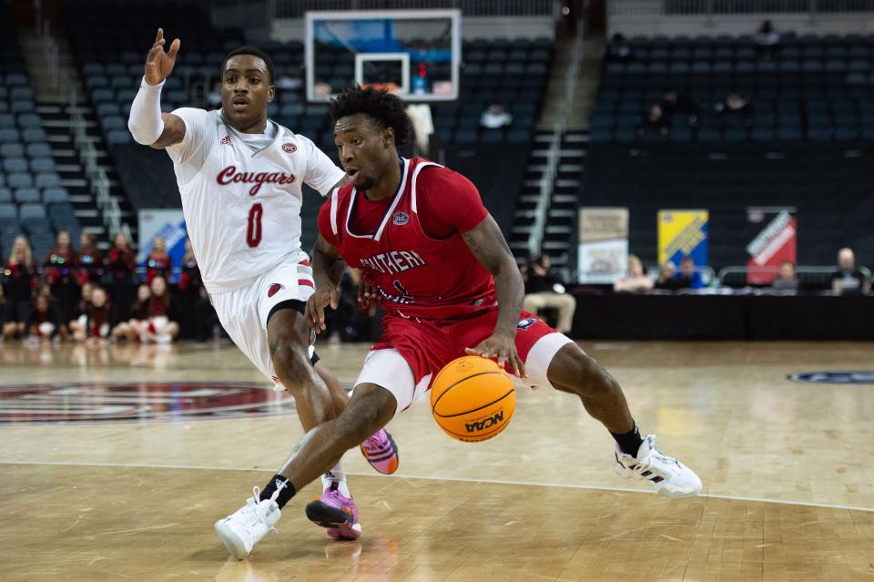 Southern Indiana’s Isaiah Swope (1) dribbles past SIU-Edwardsville’s Damarco Minor (0) during the first round of the Ohio Valley Conference at Ford Center on Wednesday night, March 1, 2023.