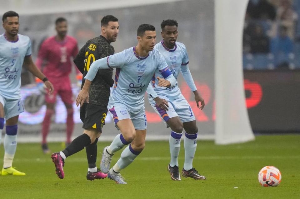 Cristiano Ronaldo (der.) busca la pelota ante la mirada de Lionel Messi, en el partido amistoso entre el Paris Saint Germain y un equipo integrado por jugadores de los clubes Al Nassr y Al Hilal, de Arabia Saudí, celebrado el 19 de enero de 2023 en Riad.