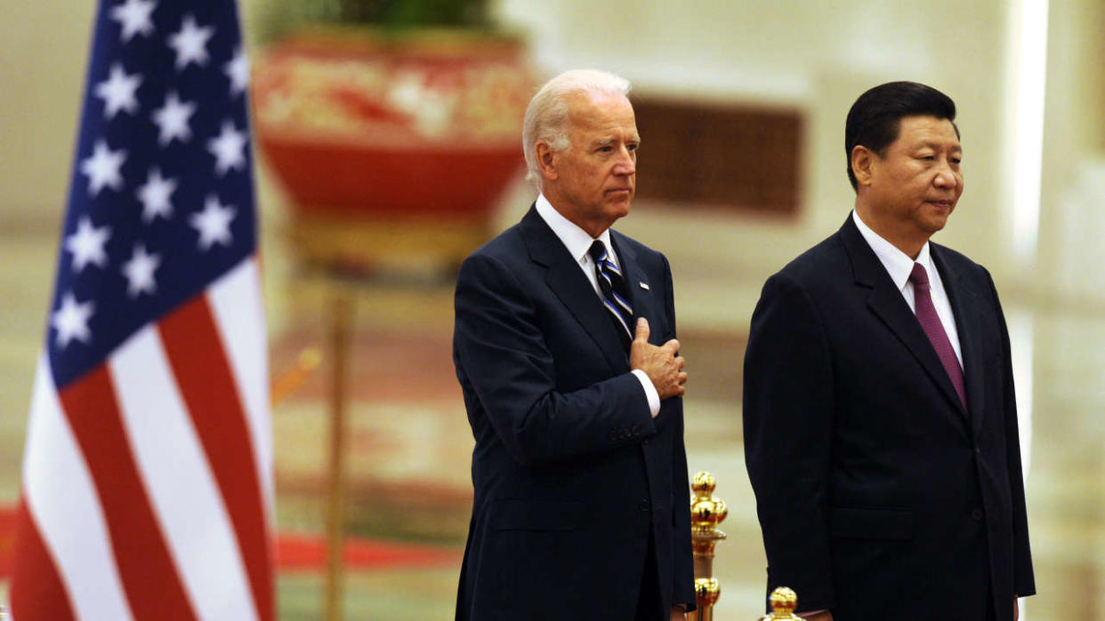 Dans cette photo d’archive prise le 18 août 2011, le président américain Joe Biden  écoute l’hymne national américain avec le président chinois Xi Jinping lors d’une cérémonie de bienvenue dans le Grand Hall du Peuple à Pékin.