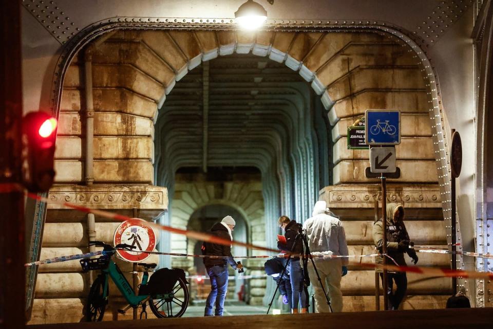 A forensic team investigate the scene following a knife attack in Paris, France (EPA)