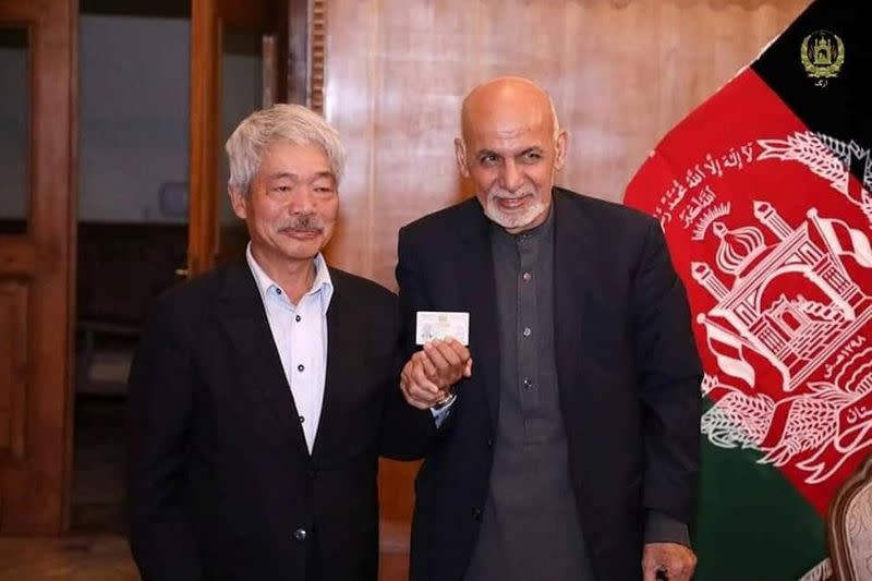 Afghanistan's President Ashraf Ghani and Japanese doctor Tetsu Nakamura pose for a photo in Kabul