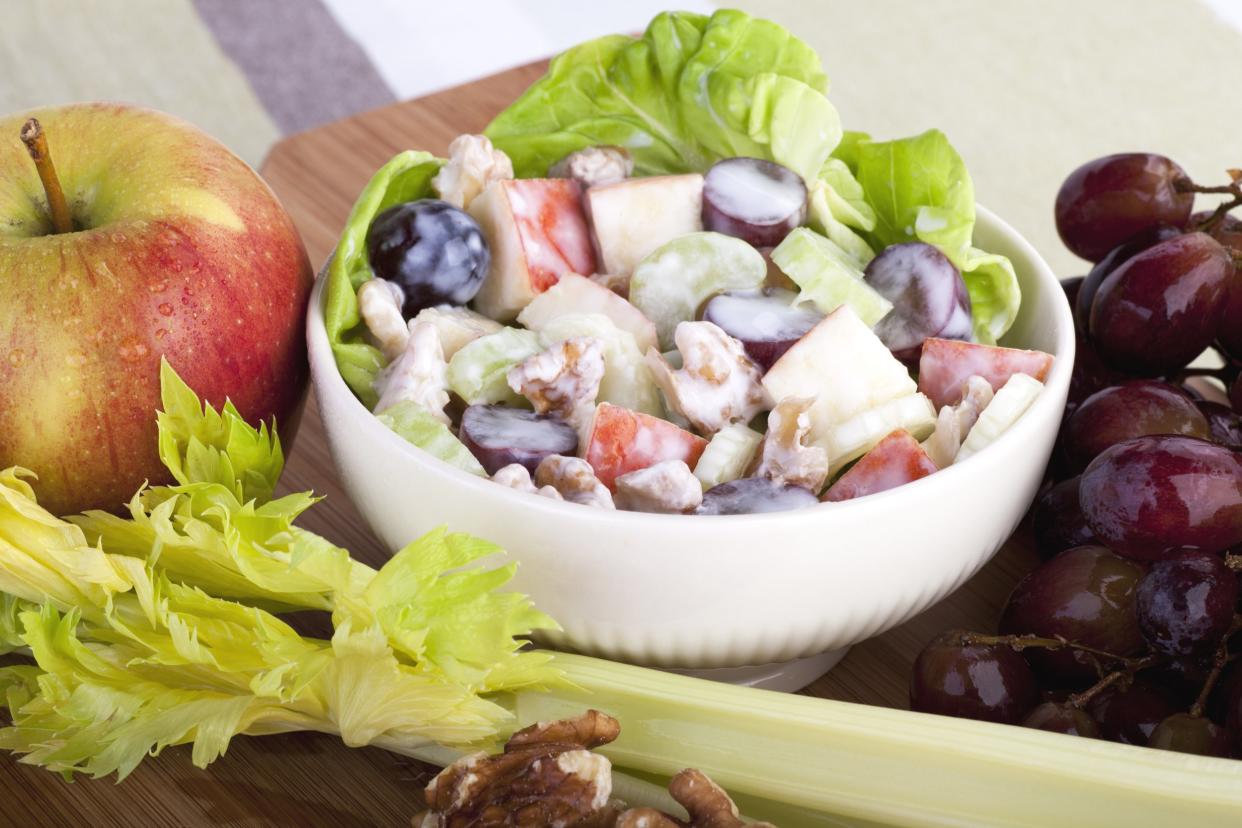 Bowl of Waldorf salad surrounded by ingredients for salad