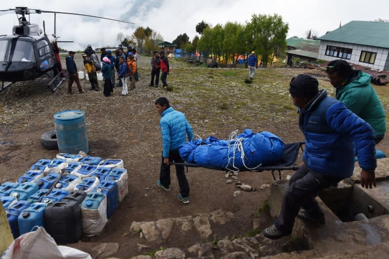 Rescuers carry the body of an earthquake victim towards a helicopter to be evacuated from the northeastern town of Lukla on April 28, 2015