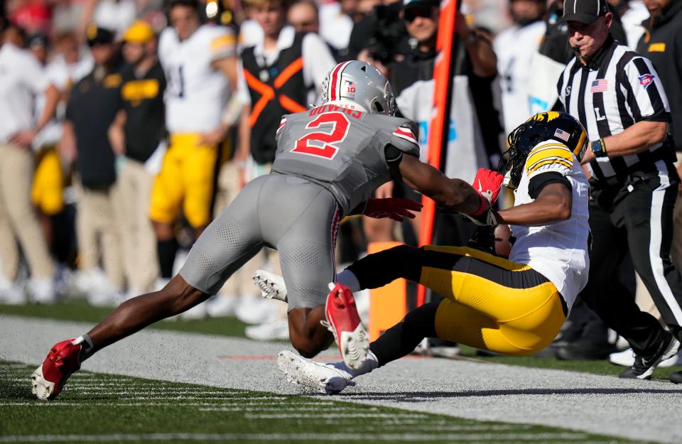 Oct 5, 2024; Columbus, OH, USA; Ohio State Buckeyes safety Caleb Downs (2) tackles Iowa Hawkeyes wide receiver Jacob Gill (5) after a catch in the first quarter during the NCAA football game at Ohio Stadium.