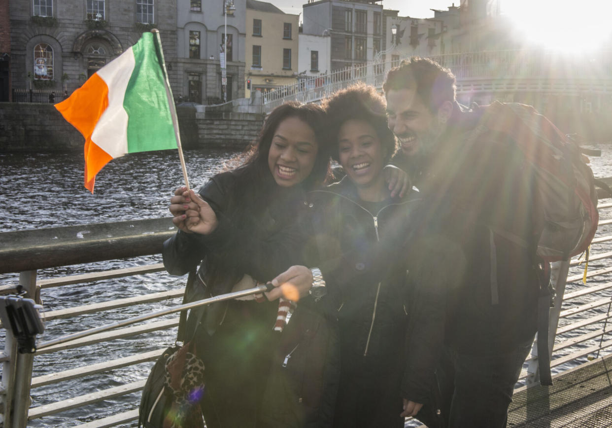 Three tourists in Dublin city centre, Ha'penny Bridge, Dublin 1, Ireland.