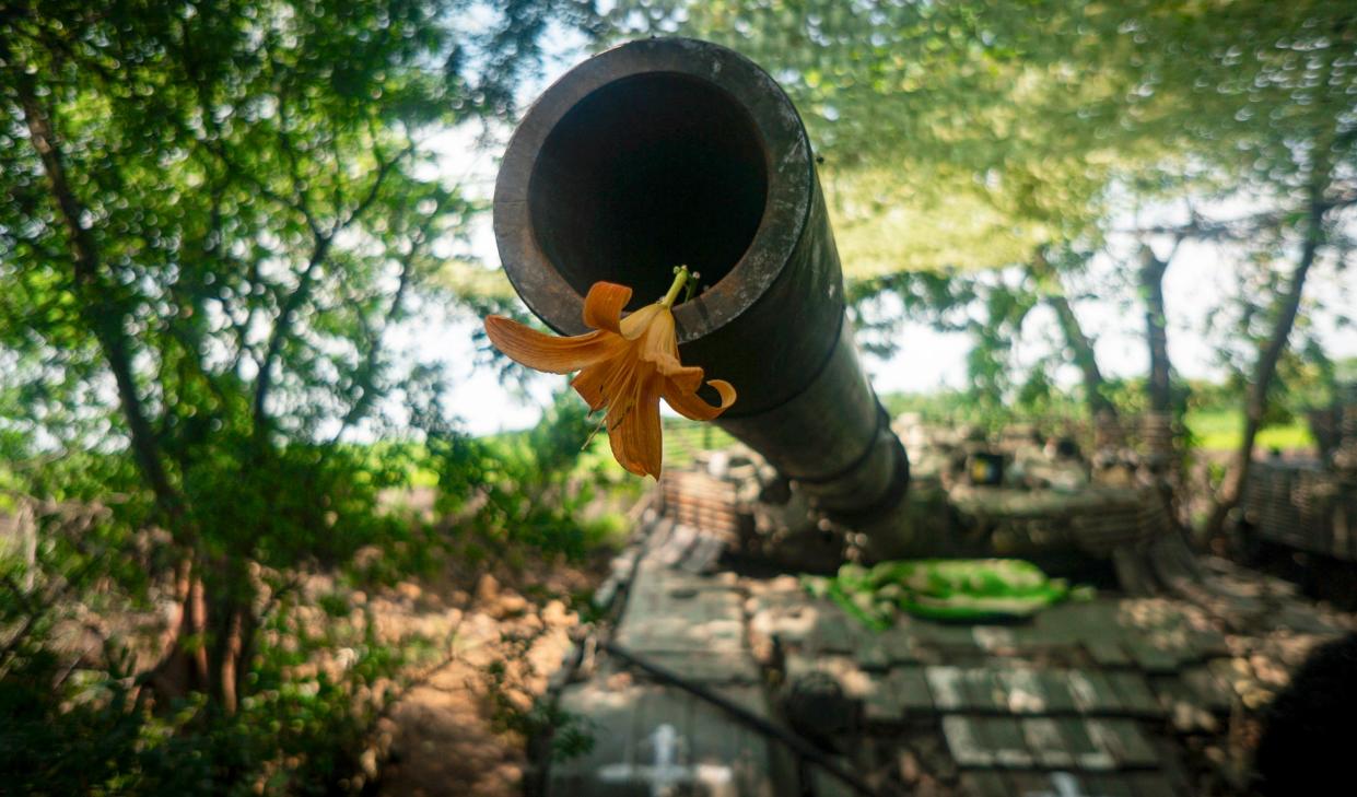 A flower resting on the mouth of a tank's gun (EPA)