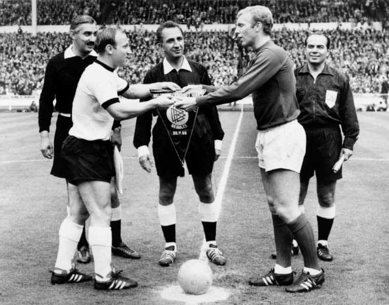 West Germany captain Uwe Seeler (left) and England's Bobby Moore exchange pennants before the start of the World Cup final at Wembley on July 30, 1966
