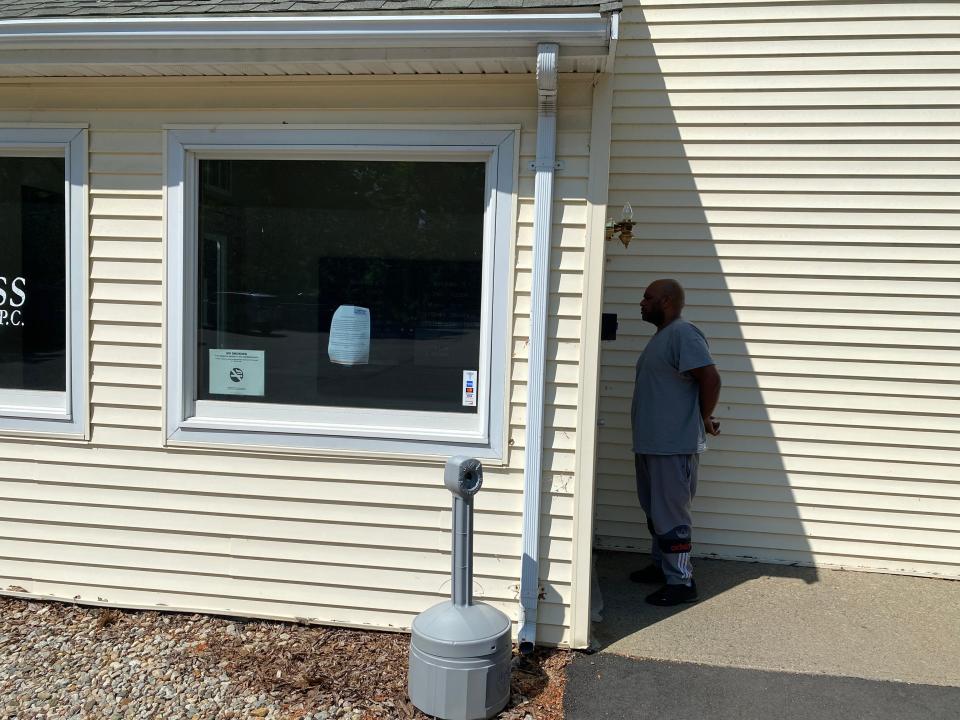 A now former patient of Compass Medical on Dean Street in Taunton on Thursday, June 1, 2023, reads the sign on the door saying his medical provider had closed abruptly.