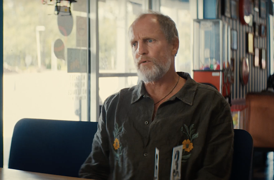 woody harrelson in suncoast, a man sits at a table at a diner talking to someone