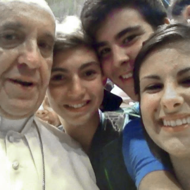 FILE - In this file photo Wednesday, Aug. 28, 2013 released Friday, Aug. 30, 2013 by Miss Deborah Arcelli and taken on a mobile phone by her son Riccardo, second from left, Pope Francis has his picture taken inside St. Peter's Basilica with youths from the Italian Diocese of Piacenza and Bobbio who came to Rome for a pilgrimage, at the Vatican. "Selfie" the smartphone self-portrait has been declared word of the year for 2013 by Britain's Oxford University Press. (AP Photo/Riccardo Aguiari, File)