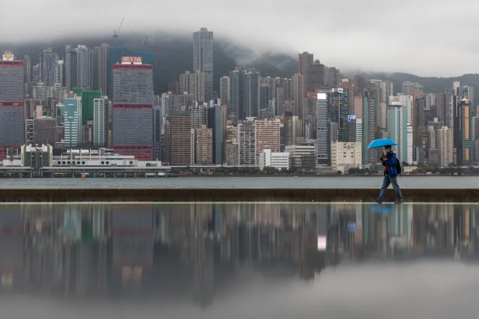 A man walks along a waterfront next to Victoria Harbour as it rains in Hong Kong on March 23, 2022. (Photo by DALE DE LA REY / AFP) (Photo by DALE DE LA REY/AFP via Getty Images)