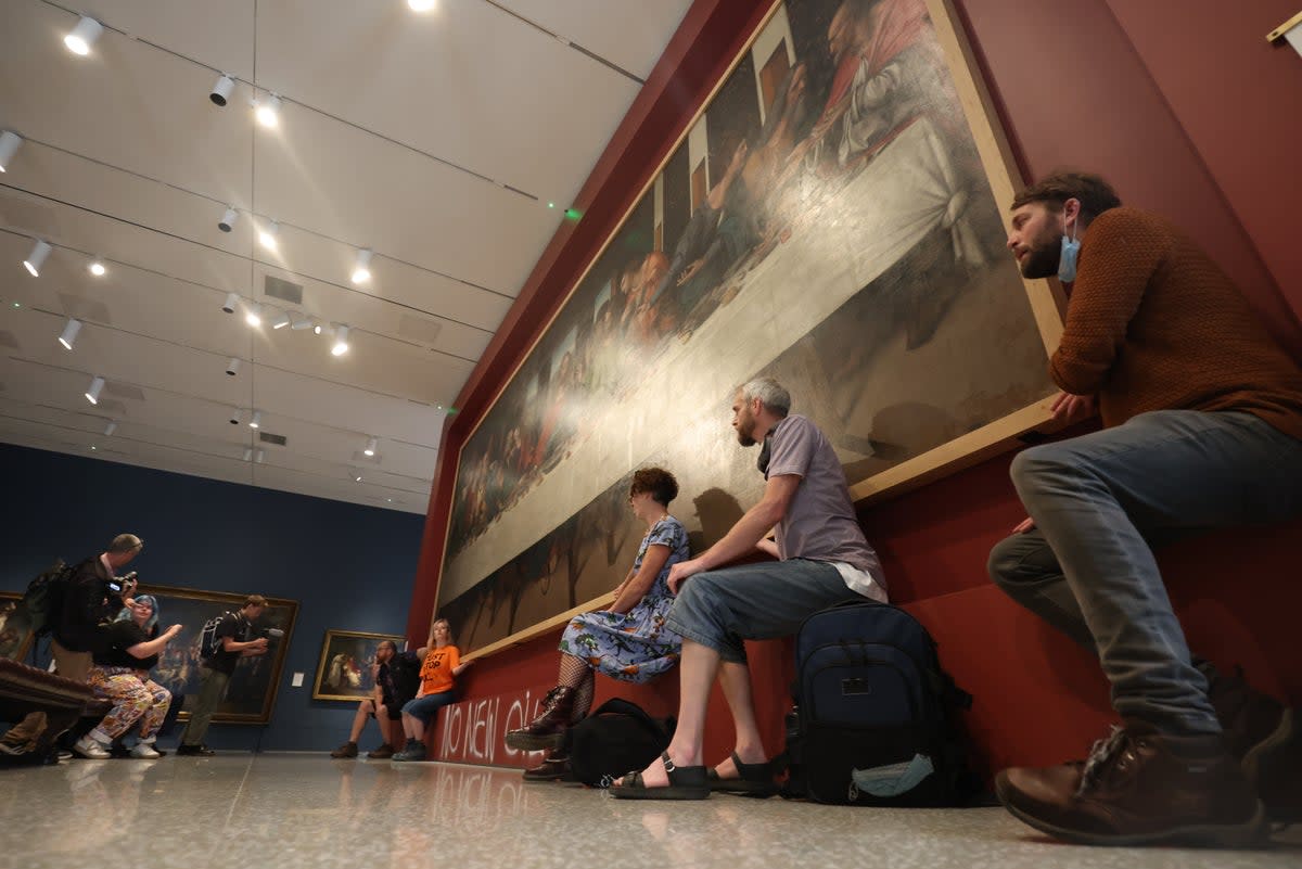 Protesters from Just Stop Oil climate protest group glue their hands to the frame of a copy of Leonardo da Vinci’s, The Last Supper (James Manning/PA) (PA Wire)